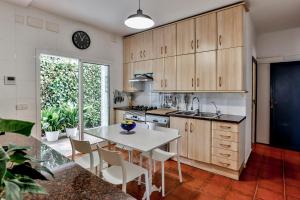 a kitchen with wooden cabinets and a white table and chairs at Casa en Sitges in Sitges