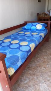 uma cama com um cobertor azul e amarelo em Paseo Aldrey em Mar del Plata