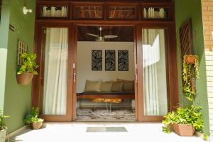 a glass door with a couch inside of a house at Pousada Dunasol Floripa in Florianópolis