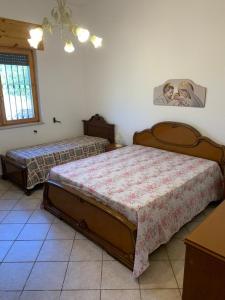 1 dormitorio con 2 camas y una foto en la pared en CASALE SOFIA E MARIAGIULIA, en Alessano