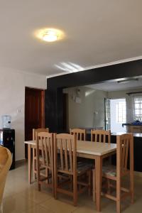ナイロビにあるNersheys 2 bedroom Apartment near Junction Mallの木製のテーブルと椅子のあるダイニングルーム