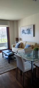 sala de estar con sofá y mesa en Acogedor apartamento con terraza en Portonovo en Portonovo