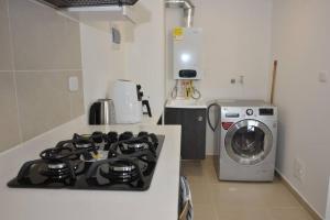 una cocina con estufa y lavadora en Hermoso apartamento en Paipa con vista al lago Sochagota., en Paipa