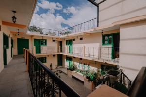 un balcón de un edificio con puertas y plantas verdes en Hotel Cielo y Selva, San Cristobal de las Casas en San Cristóbal de Las Casas