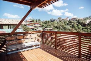 un balcone con 2 panche su una terrazza in legno di Casa de Praia no Rosa - Vista Espetacular a Praia do Rosa