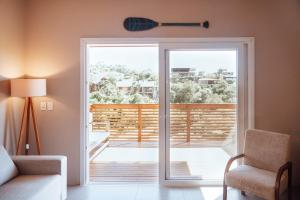 un soggiorno con una porta che si apre su un balcone di Casa de Praia no Rosa - Vista Espetacular a Praia do Rosa Altre 32 foto