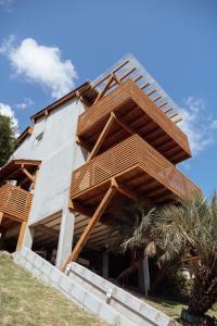una casa con balconi in legno sul lato di Casa de Praia no Rosa - Vista Espetacular a Praia do Rosa