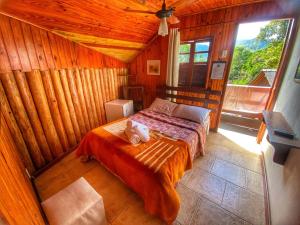 1 dormitorio con 1 cama en una habitación de madera en Pousada Colibri Serrano en Lumiar