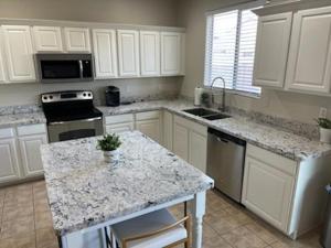 a kitchen with white cabinets and a granite counter top at Luxury in Laveen in Phoenix