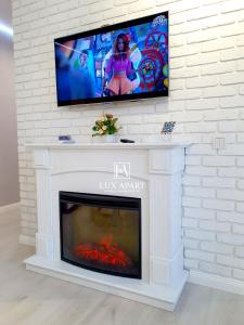 a fireplace with a flat screen tv above it at Lux апартаменты в центре Караганды на 45 квартале in Karagandy