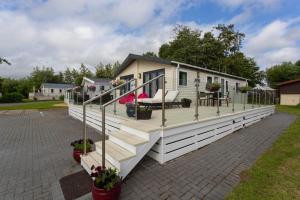 a mobile home with a large deck at Spacious Homely Lakeside Lodge close to the Beaches in Chichester
