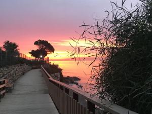 un coucher de soleil sur l'eau avec un chemin en bois dans l'établissement Casa Maria, à Estepona