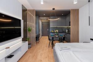 a living room with a large television and a table at Apartament Mateo Inn in Kraków