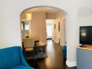 The Cottage! Chic Bungalow near Old Town Square! في فورت كولينز: غرفة معيشة مع أريكة زرقاء وطاولة