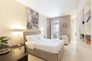 ローマにあるPetra Apartmentsのベッドルーム(白い大型ベッド1台、デスク付)