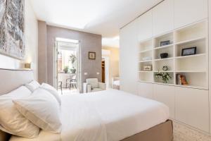 ローマにあるPetra Apartmentsの白いベッドルーム(大型ベッド1台、棚付)