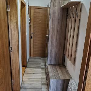 a hallway with wood paneling and a wooden door at Apartman Lea & parking u garaži in Soko Banja