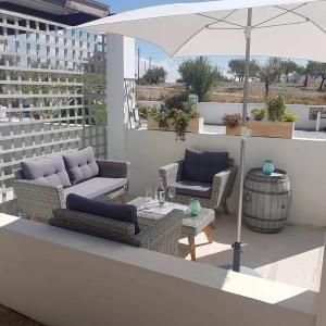 a patio with two couches and a table and an umbrella at Immaculate Casa 2 bed 2 bath with pool Casa Oriana Oria Almeria in Oria