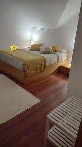 1 dormitorio con 1 cama grande y suelo de madera en A Morada de Julia, Acogedor apartamento en el balcón del Valle Miñor, en Pontevedra