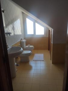 baño con 2 aseos, lavamanos y ventana en A Morada de Julia, Acogedor apartamento en el balcón del Valle Miñor, en Pontevedra