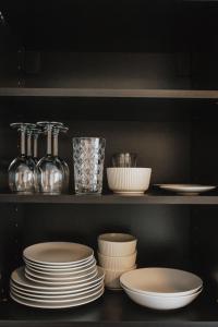 a shelf with plates and other dishes in a kitchen at Rozenstein design residence in Brocēni