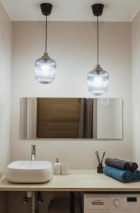 dos luces colgando sobre un lavabo en un baño en Rozenstein design residence, en Brocēni