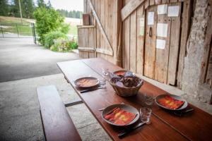 una mesa de madera con platos de comida. en Ferme O'Clés en Le Peuchapatte