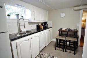uma cozinha com armários brancos, um lavatório e uma mesa em Close to UNC with Great Yard, Firepit & Free Bikes! em Greeley