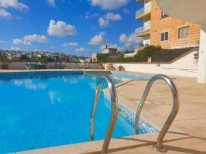 een zwembad met blauw water in een gebouw bij Spinola Court Apartment with Pool and close to beach St Julians Center in St Julian's