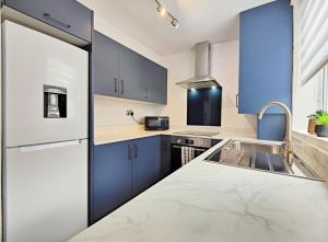 a kitchen with blue cabinets and a counter top at Spacious Townhouse 5 Mins to Liverpool City Centre With Free Parking in Liverpool