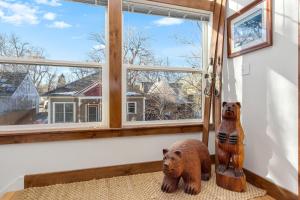 two wooden bear statues sitting on a rug in front of a window at The Beautiful Bears Den! Walk to Old Town and CSU! in Fort Collins