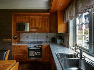 a kitchen with wooden cabinets and a sink and a stove at Great apartment in Trysil, ski inout, wifi, sauna in Trysil +17 photos