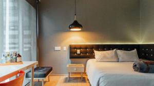 a bedroom with a bed and a table and a desk at The Click Clack Hotel Bogotá in Bogotá