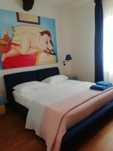 - une chambre avec un lit et une peinture d'une femme sur le lit dans l'établissement La casa di Sacco - Appartamento Bologna Centro, à Bologne