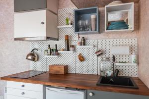 a kitchen with white cabinets and a wooden counter top at Beautiful Tiny house on the lake side. in Trakai