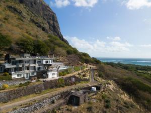 a house on the side of a hill with the ocean at Villa Cambier by muse villas in Le Morne +39 photos
