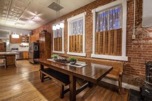 柯林斯堡的住宿－Elegant Loft-Style Retreat in Old Firehouse Alley，厨房配有木桌和砖墙