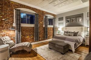 a bedroom with a bed and a brick wall at Elegant Loft-Style Retreat in Old Firehouse Alley in Fort Collins +22 photos