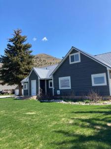 una casa nera con un albero in un cortile di Afton Farmhouse with Mountain Views a Afton