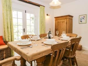 a dining room with a wooden table and chairs at Caldhu Cottage in Holmrook