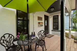 a table with two chairs and a green umbrella at Lola House! Cozy Comfort, Prime Old Town Location in Fort Collins