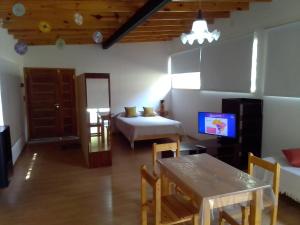 Habitación con cama, mesa y TV. en Las Moras en Villa Giardino