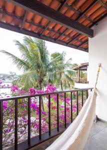 a hammock on the balcony of a resort with flowers at Apartamento em Búzios com suítes e piscina |CLC 11 in Búzios
