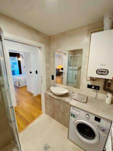 ein Badezimmer mit Waschbecken und Waschmaschine in der Unterkunft Apartamento en Edificio Nuevo con Piscina in Portonovo