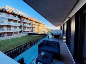 einen Blick vom Balkon eines Gebäudes mit Pool in der Unterkunft Apartamento en Edificio Nuevo con Piscina in Portonovo