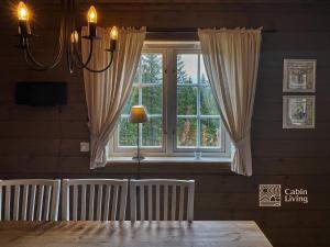 una sala da pranzo con una grande finestra con tende di Flat in Trysil Ski in ski out and sauna a Trysil