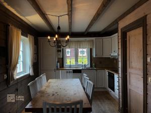 トリシルにあるNice apartment in Trysil ski in-out, sauna and viewのキッチン(木製のテーブル、椅子付)、ダイニングルーム