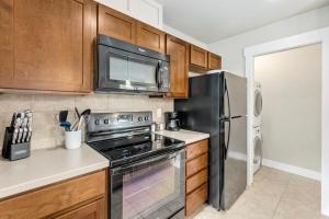 a kitchen with a stove and a microwave at Contemporary Studio - Sunny, Stylish and Spacious in Fort Collins