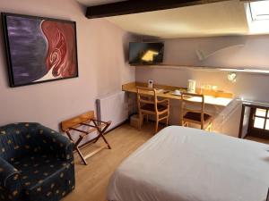 a room with a bed and a table and a chair at Hostellerie Au rendez-vous des amis in Chaumont