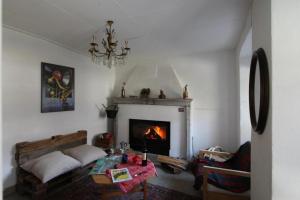 a living room with a fireplace and a table at Camera in Casa Eva in Brione